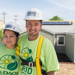 Two people by solar panel